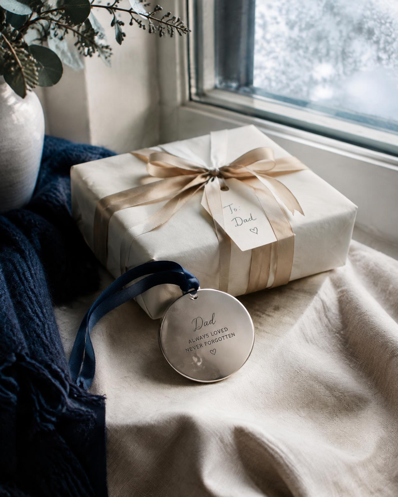 Engraved keepsake ornament beside a wrapped gift